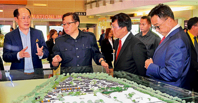 Abang Johari (second left) and Wong (third left) looks on at a model of a house during his tour of the Sheda Property Expo 2016 yesterday.