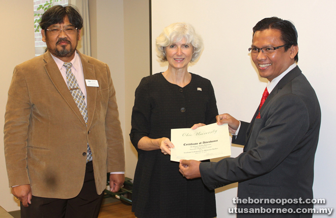 Dr Lorna (centre) presents a certificate of attendance to one of the Graduate Colloquium on Malaysian Studies participants, Al Azharri Kamunri who his doing his PhD at UPM and works for the National Security Council of the Prime Minister Department, Malaysia. Looking on is Dr Jayum.