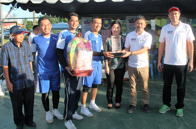 Ripin presenting his trophy to Veteran champion Masuka Kastam, witnessed by (from left) Yvonne, Aries and Hamdan.