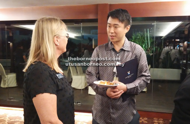 Larry Sng (right) speaks to admission assistant Ali Pick.