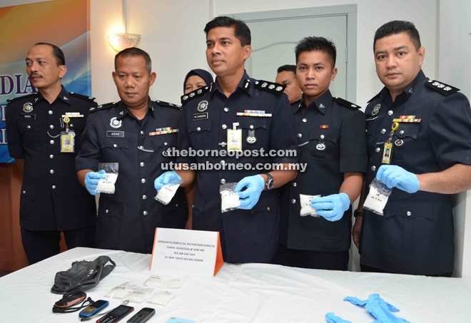 Chandra (centre) with Mohd Azhar (second left), Azizulkifli (left) and other police officers with the seized drugs.