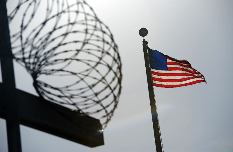 A US flag flies above a razorwire-topped fence at the "Camp Six" detention facility December 10, 2008 at the US Naval Station in Guantanamo Bay, Cuba. AFP Photo