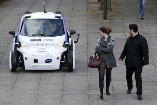 Bystanders look at an autonomous self-driving vehicle as it is tested in a pedestrianised zone during a media event in Milton Keynes, north of London, on October 11, 2016 -AFP photo