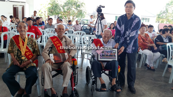 Fu Jijun (standing, right) with the three war heroes – (from left) Kho Hai Seng, Lee Ah Liew and Fong Chen Piao, all aged over 100 years old.