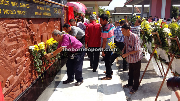 Guests pay their last respects to the fallen heroes after the unveiling of the WWII Memorial for Sarawak Volunteer Mechanics and Drivers in Kuching. 