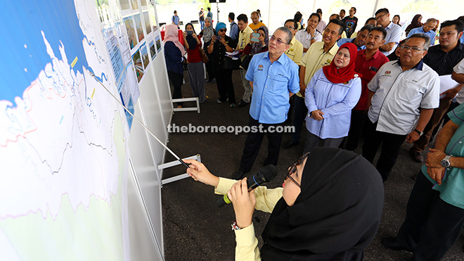 (From left) Fadillah and Kota Samarahan MP Rubiah Wang listen to a briefing at the project site.