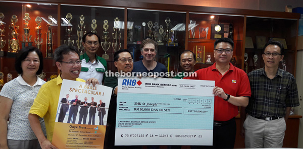 Ling (second right) hands over the cheque to Lau. From left are June and Dr Sim as well as committee members. Jonathan is on second left, back row. 