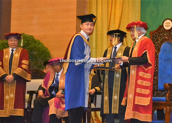 Taib accompanied by Wong (left), Adenan (seated) hands over a scroll to a graduate.