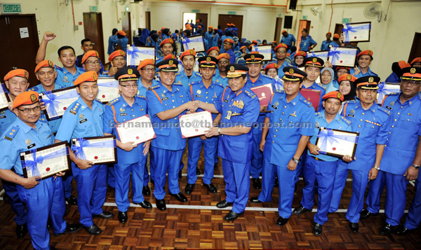 Selamat (right) congratulating one of the Civil Defence Department personnel after the conferment of ranks for officers in Seremban.— Bernama photo 