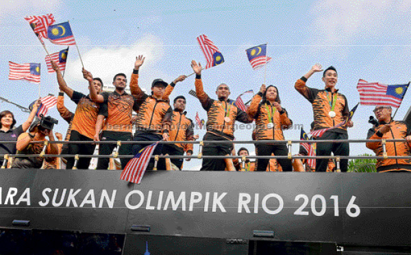 Pandelela Rinong (third right) with Datuk Lee Chong Wei (second right) and other Malaysian Rio Olympics athletes and officials on the open top bus during the National Day parade at the Dataran Merdeka in Kuala Lumpur yesterday. — Bernama photo