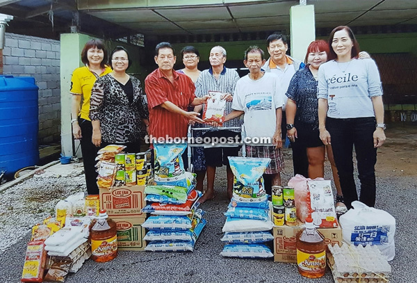 Lim (third left) seen with Kudip (fifth left) and Ligey (fourth right) during his visit to Kampung Bogag to hand over donations in the form of food items recently. Also seen are Ator (second left) and others.
