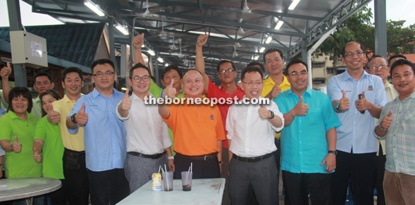 Dr Sim (fourth right, front row), Chan (fifth right, front row) and others giving the thumbs-up to the extended roof.