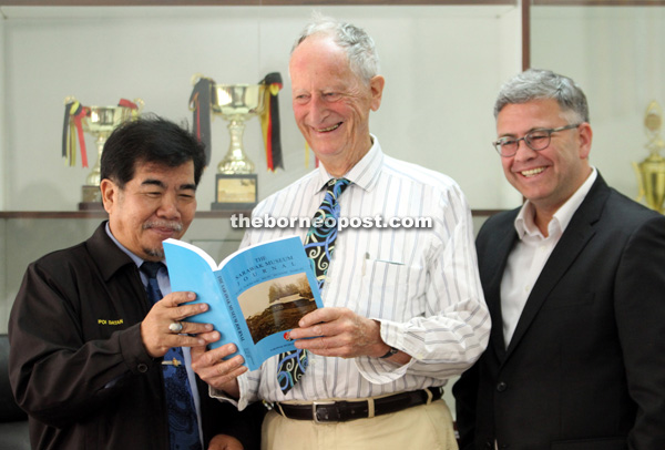 Gathorne-Hardy flips through a Sarawak Museum Journal together with Ipoi and van de Bunte. — Photo by Chimon Upon