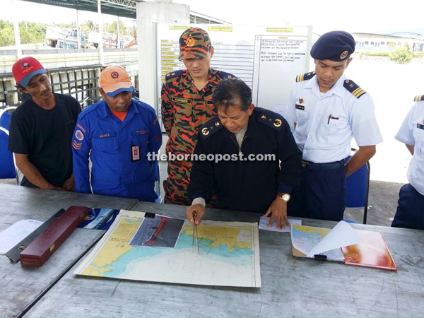 Hamdi (left) watches as Ismaili (second right) coordinates the SAR efforts for the various departments and agencies involved at Tun Abang Salahuddin Maritime Complex in Muara Tebas.