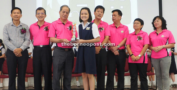 Ling hands over the individual champion trophy to Yun En. Also seen from left are Liu, Sing Seng, Ong and others.