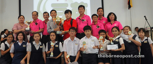 Liu (standing fourth from left) presents the challenge trophy to CHPS No 3 teacher Chong Soon Cheng while Ling (standing second from left) hands over the champion trophy to CHPS No 3 teacher Jong Ma Li.