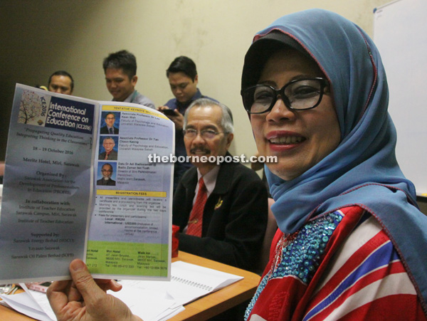 Fatimah holds the conference pamphlet while Zulwali looks on. — Photo by Jeffery Mostapa