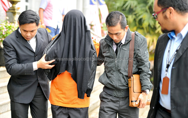 The 65-year-old suspect (second left) under remand for a week to assist in the misappropriation of funds in a RM15 million book publishing contract. — Bernama photo