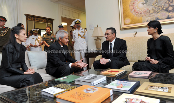 Hishammuddin and his wife Tengku Marsilla (right) with Thai ambassador to Malaysia, Damrong Kraikruan (second left) after signing the condolence book at the Thai embassy. — Bernama photo