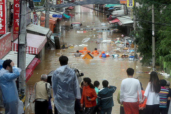 A road is submerged in flood waters caused by Typhoon Chaba as residents look on in Ulsan, South Korea on Oct 5. – Reuters photo