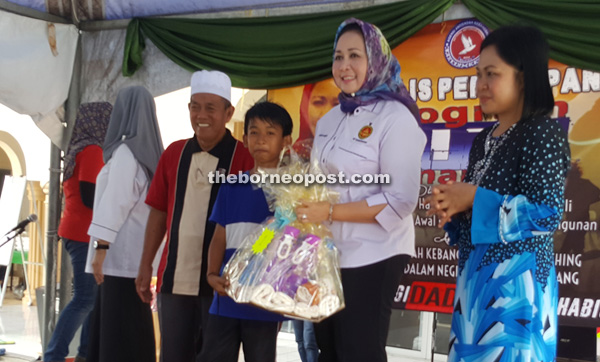 Hasidah presenting a prize to the winner of the Explorace programme as Kartini looks on.