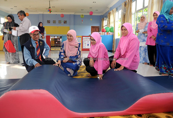 Mohammad Omar (left) and Ramlah (second left) checking on the cleaning process at one of the nurseries in Kuala Terengganu. — Bernama photo