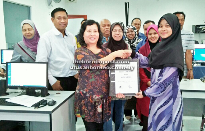 Hamisa (fourth left) witnesses the handing over of the e-Desa building, computer equipement from the ministry's assistant secretary chief Moira David (third left) and appointment letter to the administrator.