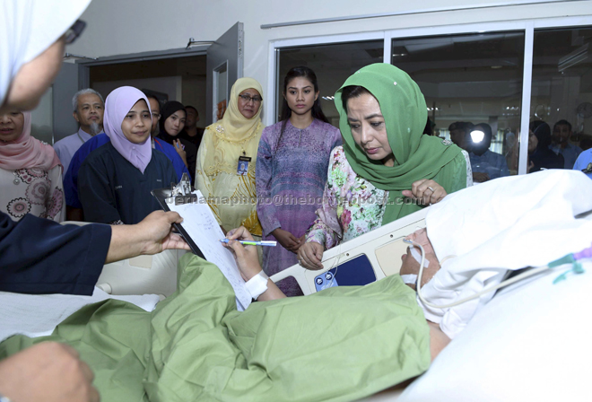 Raja Zarith Sofiah (right), visits the injured staff and patients from the hospital admitted to the Sultan Ismail Hospital. — Bernama photo