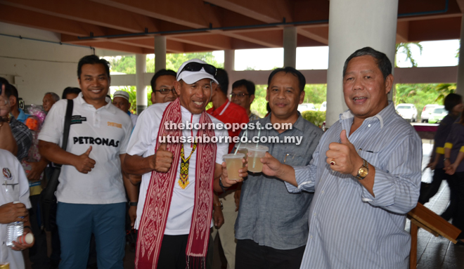 Nogeh (right) gives the thumbs-up to the refreshing drink of kelulut honey. With him are Henry (second right) and Sabri (second left). — Photo by Mohd Rais Sanusi 