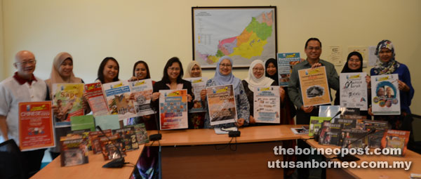 Rashidah (fifth right) holding the carnival poster with library staff. — Photo by Wilfred Pilo  