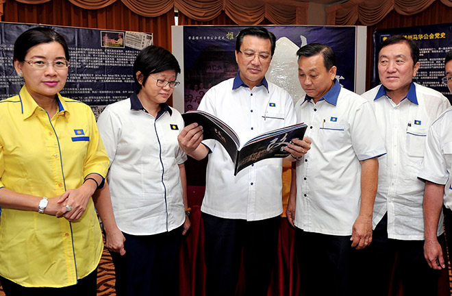Liow (centre) takes a look at a book after opening the simultaneous annual conventions of Terengganu MCA’s Youth and Women’s wings. — Bernama photo