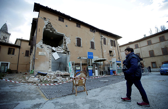 A police officer stands next to a collapsed building after an earthquake in Visso, central Italy. — Reuters photo