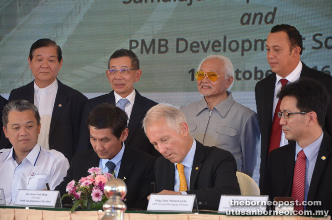 Taib (standing second right) and others witness the MoU signing ceremony between Samalaju Properties represented by Curtis (seated second right) and PMB Development by its director Koon Poh Ming (seated second left).
