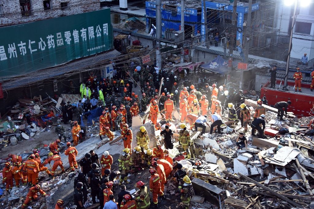 Rescuers search for survivors at an accident site after four buildings caved in, in Wenzhou, eastern China's Zhejiang province, on Oct 10, 2016. AFP Photo