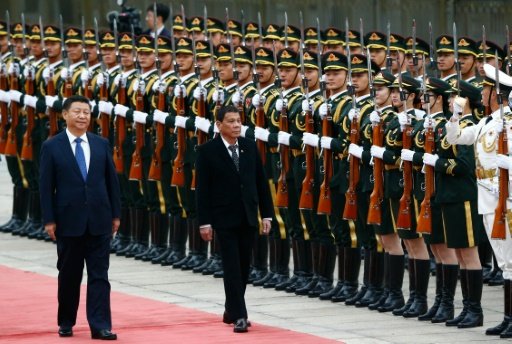 Philippine President Rodrigo Duterte (C) and Chinese President Xi Jinping review the guard of honour as they arrive for a welcoming ceremony at the Great Hall of the People in Beijing, on October 20, 2016. - AFP