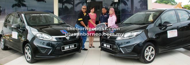 Zairi (left) handing over the mock keys for two units of new Proton Iriz to Norhazana, while Jupri (second from right) and Lee (second from left) look on at Institut Memandu Cemerlang yesterday.