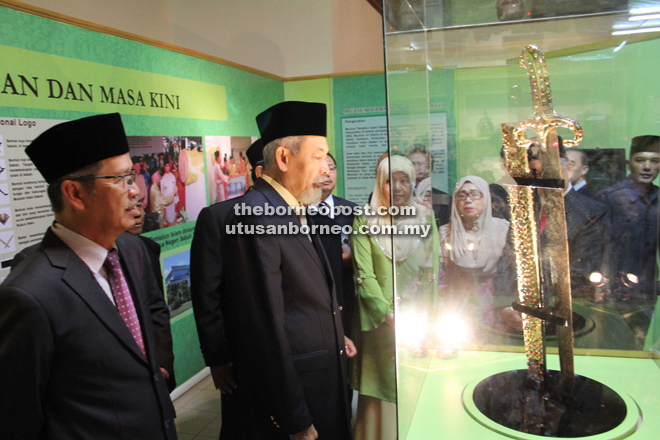 Juhar looking at a sword which is a replica of the one owned by Prophet Muhammad. Standing behind him is Kamarlin.