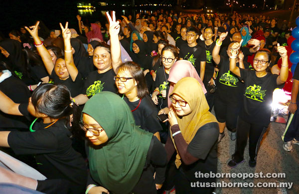 Unimas students in good spirits despite the drizzle. — Photo by Mohd Rais Sanusi