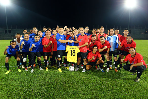 Chua (centre, right) hands over the official Jin Hua Sport Club kit to team captain Wong Sai Kong prior to the kick-off. — Photo by Muhammad Rais Sanusi