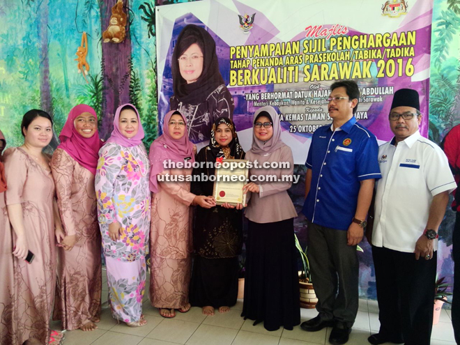 Dayang Monalizawati (fourth left), Sharifah Hasidah (third left), Dr Hazland (second right) and others look on as Fatimah (third right) presents the certificate to Noorirwaniee (fifth left). 