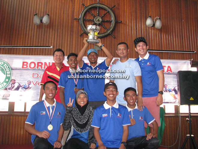 Ahmad Yusoff celebrates with other members of the SAILA team as he lifts the Hales Trophy. On the left is SYC commodore Richard Lim 
