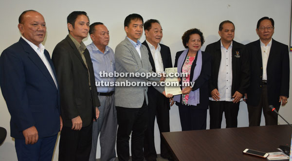 Hii (fourth left) hands over the appointment letter to Penghulu Evelyn, witnessed by Wong (fifth left), Temenggong Lau (right), Stanley (third left) and others.