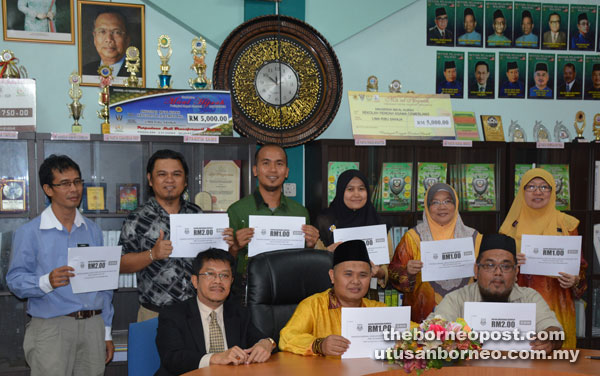 Saidal (seated centre), Yusop (seated left), Kassim (seated right), Mohamad Safree (standing second left) and others holding up coupons for the BSN School Carnival 2016 to be held at SK Agama on Nov 12 .