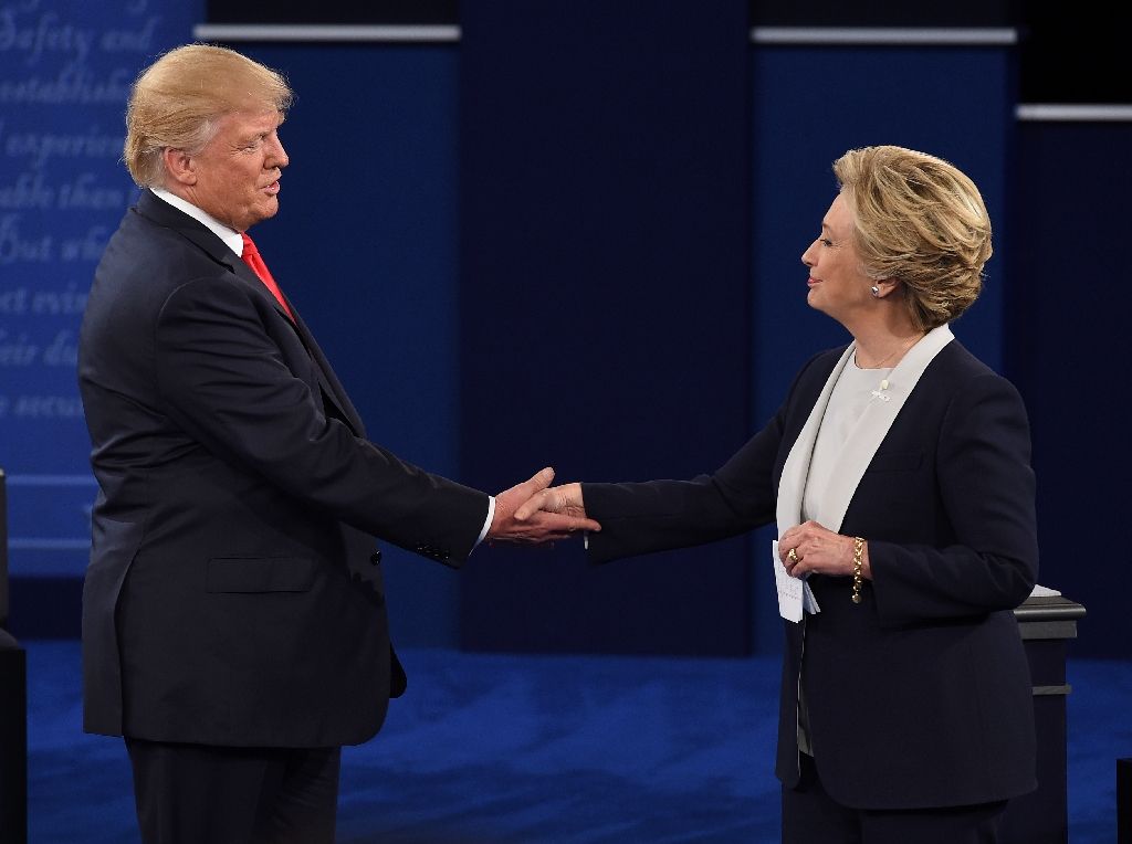 US Democratic presidential candidate Hillary Clinton (R) and US Republican presidential candidate Donald Trump shake hands at the end of the second presidential debate. AFP Photo