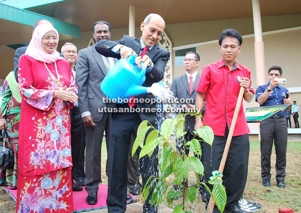 Mohd Bakke waters a newly-planted tree to symbolically launch the CEO@Faculty Programme at UPMKB, as Dr Aini (left) and other guests look on.