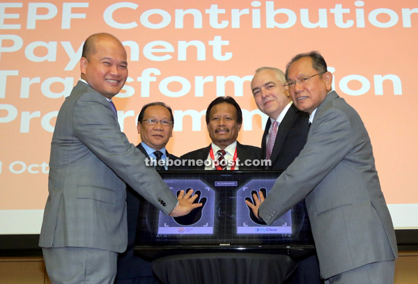 Shahril (left) along with Malaysian Communications and Multimedia Commission chairman Datuk Seri Halim Shafie (right) and other honoured guests after the launch of the e-Caruman Contribution Payment Transformation Programme.