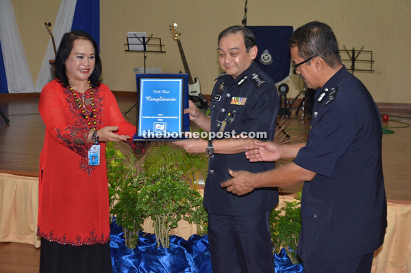 Mazlan (second right) presents a memento to Kuching Division Journalists Association (KDJA) chairperson Jacqueline Atiqah. At right is State Crime Prevention and Community Safety Department head SAC Che Yussof Che Ngah.