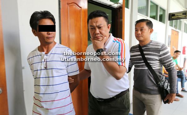 REMAN: Suspek (kiri) dibawa keluar dari mahkamah selepas ditahan reman lima hari. 