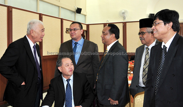 Some of the Penang assemblymen speaking with Exco for Welfare, Caring Community and Environment Phee Boon Poh (left) and Exco for Tourism Law Heng Kiang (seated) before the assembly sitting yesterday. — Bernama photo 