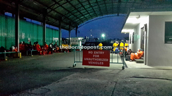 Petronas workers waiting at a private jetty in Kampung Pulau Melayu, Miri to be ferried to their offshore workplaces at 5am yesterday.